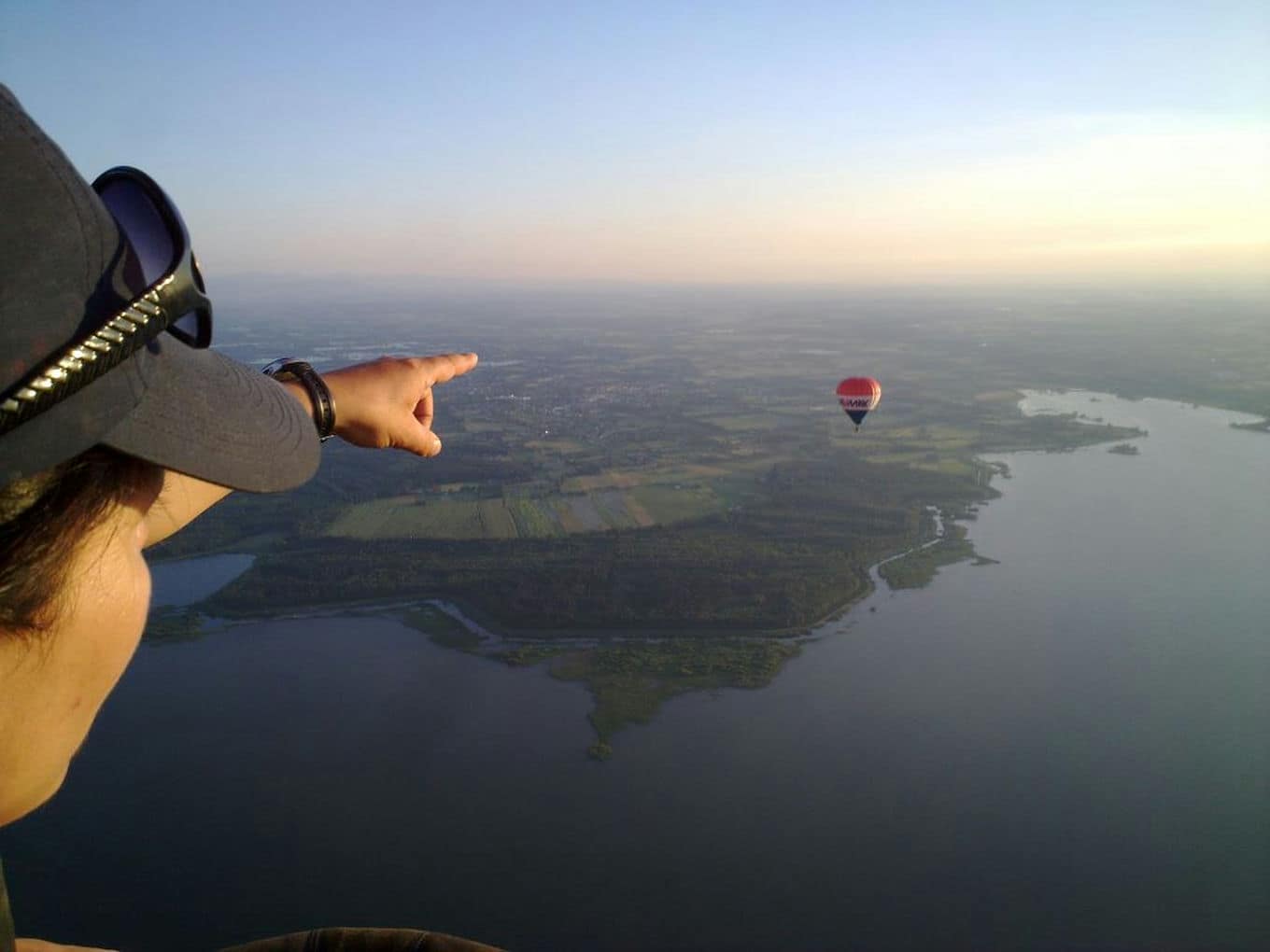 mężczyzna wskazuje palcem lecący balon
